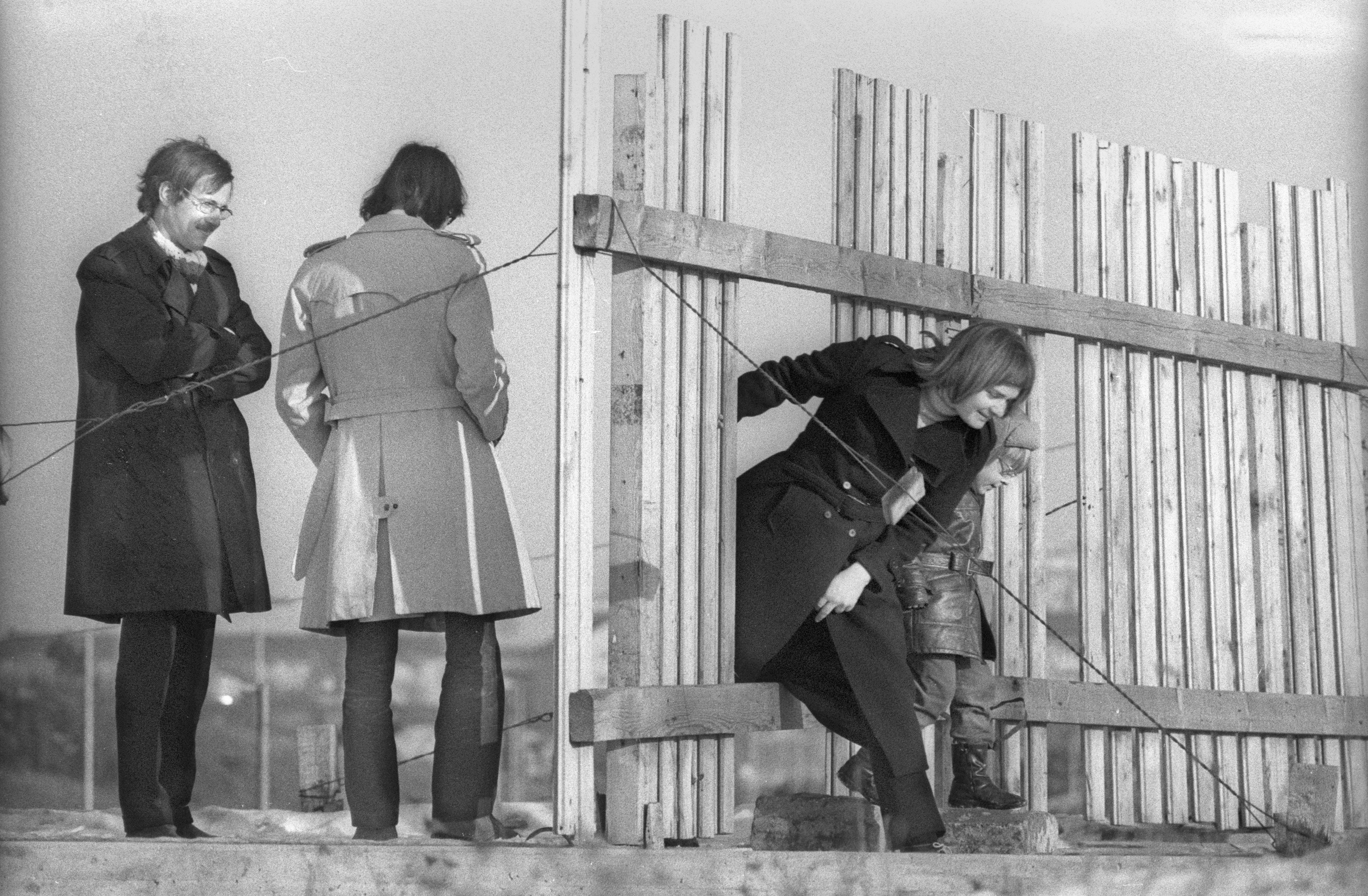 Austelle auf dem Olympiagelände 1970. Eine Frau mit Kind klettert durch die Absperrung
