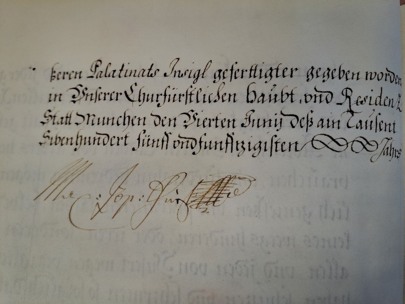 Ausschnitt der letzten Pergamentseite des Adelsbriefs mit Unterschrift; vier Zeilen Text in Frakturschrift in dunkler Tinte, darunter die eigenhändige Unterschrift in hellbrauner Tinte