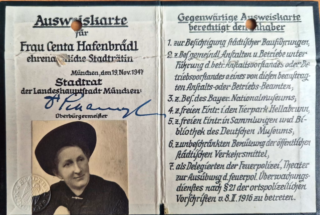 Das Bild zeigt den Dienstausweis von Centa Hafenbrädl als Stadträtin aus dem Jahr 1947. Sie trägt einen großen Hut und auf dem Ausweis sind die Vergünstigungen, die eine Stadträtiin genoss, unter anderem freie Eintritte in Museen, verzeichnet.